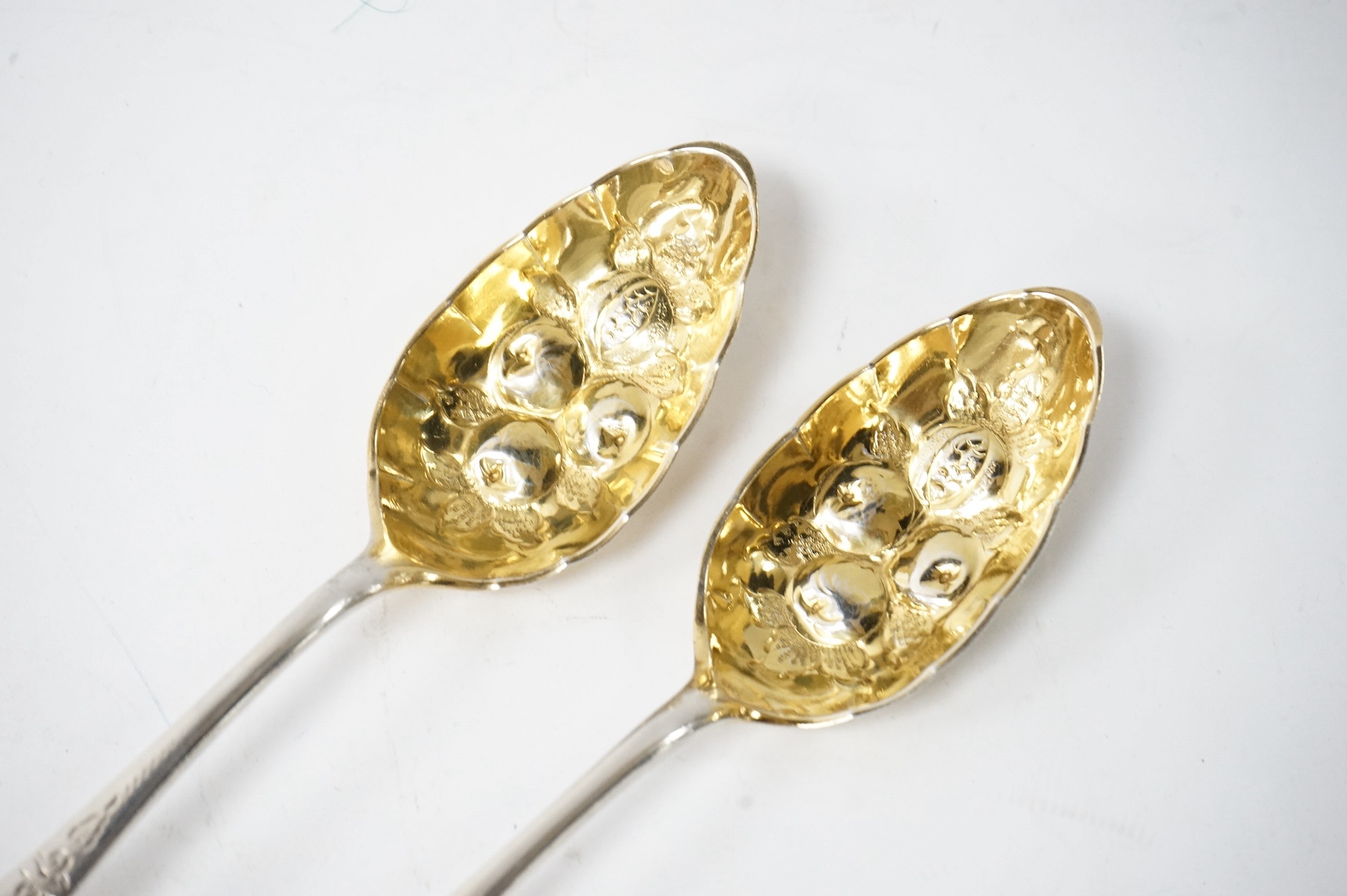 A pair of late 18th/early 19th century German parcel gilt white metal Celtic tip berry spoons, with engraved foliate decoration, maker's mark WHG? in italic, stamped with rampant lion below 13 probably Heidelberg city ma